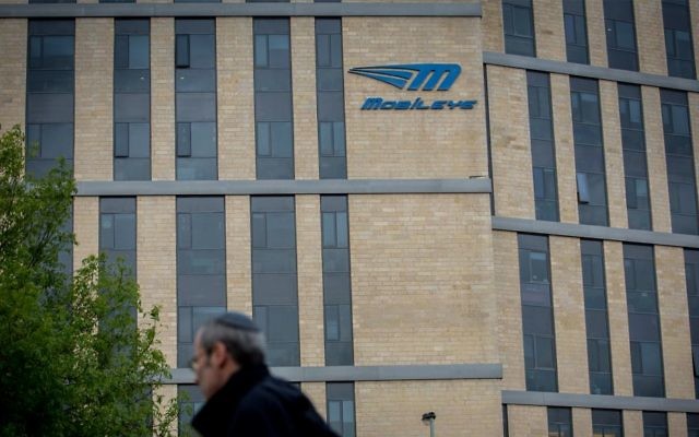 A man walks under the Mobileye logo in Jerusalem, March 13, 2017. (Yonatan Sindel/Flash90)