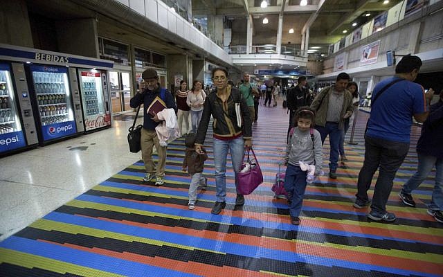 In this March 17, 2017 photo, Jewish converts Sahir Quitero, center, her husband Franklin Perez, son Ezra, left, and daughter Hannah, walk to departures lounge of the Simon Bolivar International Airport in Maiquetia, Venezuela, on their way to Israel. (AP Photo/Fernando Llano)