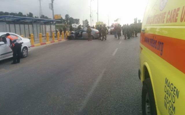 Israeli troops surround a car that was driven into a bus stop in an apparent terror attack in the Etzion Junction in the West Bank on March 15, 2017. (Magen David Adom) Israeli troops surround a car that was driven into a bus stop in an apparent terror attack in the Etzion Junction in the West Bank on March 15, 2017. (Magen David Adom)