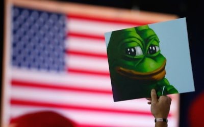 A Donald Trump supporter holds a cartoon designated a hate symbol by the anti-defamation league before the start of a campaign event in Bedford, NH, on Sept. 29, 2016.  (Jessica Rinaldi/The Boston Globe via Getty Images)