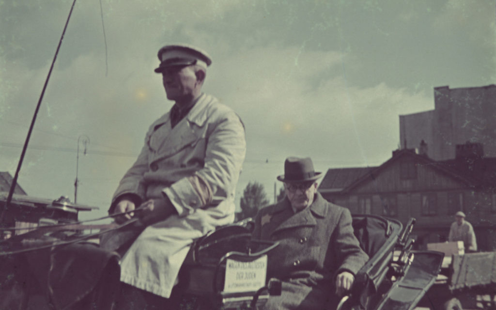 During his tenure as chairman of the Lodz Ghetto's Nazi-installed Jewish Council, Chaim Rumkowski is driven by a horse-drawn carriage through the ghetto (United States Holocaust Memorial Museum)