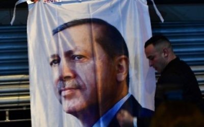 A man gestures in front of a flag bearing a portrait of Turkish President Recep Tayyip Erdogan as Turkish residents of the Netherlands protested outside Turkey's consulate in Rotterdam on March 11, 2017. / AFP PHOTO / Emmanuel DUNAND A man gestures in front of a flag bearing a portrait of Turkish President Recep Tayyip Erdogan as Turkish residents of the Netherlands protested outside Turkey's consulate in Rotterdam on March 11, 2017. / AFP PHOTO / Emmanuel DUNAND