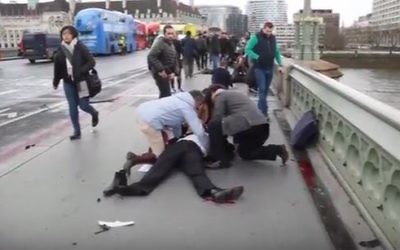 Passersby care for a victim of a terror attack outside British Parliament in London on March 22, 2017. (Screen capture/YouTube)