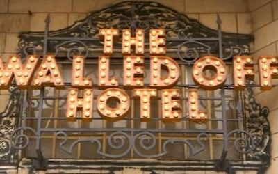The lit-up sign at the front of Banksy's Walled Off Hotel in Bethlehem. (Screen capture/YouTube)