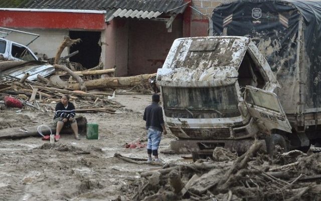 People stare at damages caused by mudslides following heavy rains in Mocoa, Putumayo department, southern Colombia on April 2, 2017. (AFP PHOTO / LUIS ROBAYO)
