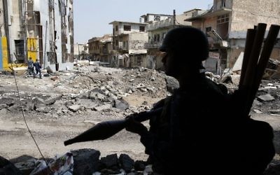 A member of the Iraqi federal police holds a rocket propelled grenade (RPG) as troops advance near the Old City in western Mosul on April 2, 2017, during the offensive to retake the city from Islamic State (IS) group fighters. (AFP/Ahmad Gharabli)
