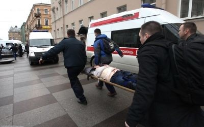 Men carry an injured person on a stretcher outside the Technological Institute metro station in Saint Petersburg on April 3, 2017. (AFP Photo/Inter Press/Alexander Tarasenkov)