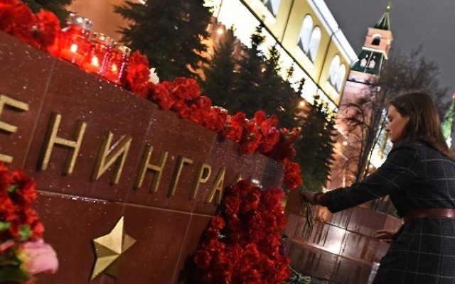 A woman lays flowers in memory of victims of the blast in the Saint Petersburg metro at a memorial stone reading Leningrad by the Kremlin wall in central Moscow on April 3, 2017. (AFP Photo/Vasily Maximov)