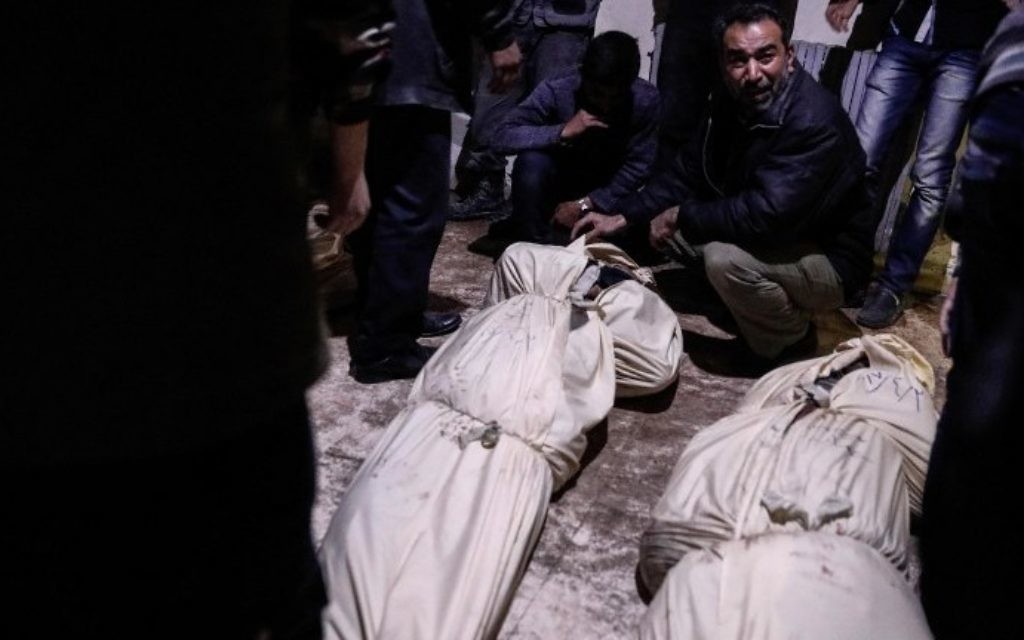Relatives react as they identify bodies of victims following reported air strikes by government forces in the rebel-held town of Douma, on the eastern outskirts of Damascus, on April 3, 2017. (AFP PHOTO / Sameer Al-Doumy)