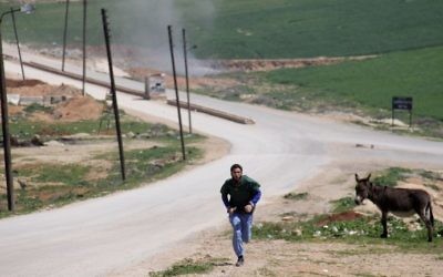  A Syrian medic runs for cover during the air strikes which hit a hospital in Khan Sheikhun, a rebel-held town in the northwestern Syrian Idlib province, on April 4, 2017. (AFP Photo/Omar Haj Kadour)