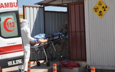 Turkish officials with chemical clothes carry a injured man on April 4, 2017 in Hatay province, near the Syrian border. (AFP/ DOGAN NEWS AGENCY)