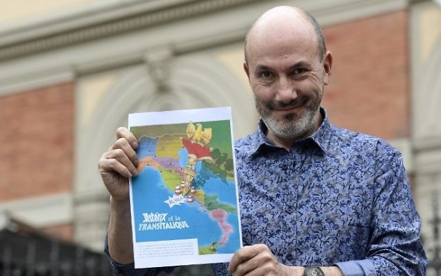 French comics writer, designer and colourist Jean-Yves Ferri poses with the future front page of the 37th album of the Asterix series "Asterix et la Transitalique" (in French) whose adventures will take place in italy, after a press conference in Bologne, April 5, 2017. (AFP/MIGUEL MEDINA)