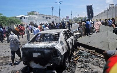 Illustrative: People stand at the site of a car bomb near a restaurant near the Somali ministry of internal security in Mogadishu on April 5, 2017. (AFP Photo/Mohamed Abdiwahab)