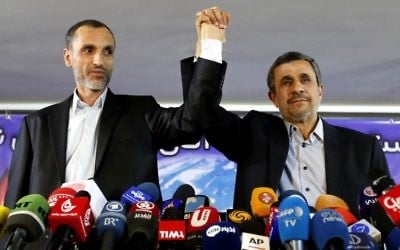 Former Iranian president Mahmoud Ahmadinejad (R) and his former vice president, Hamid Baghaie, lock hands during a press conference in the capital Tehran on April 5, 2017. (AFP PHOTO / ATTA KENARE)