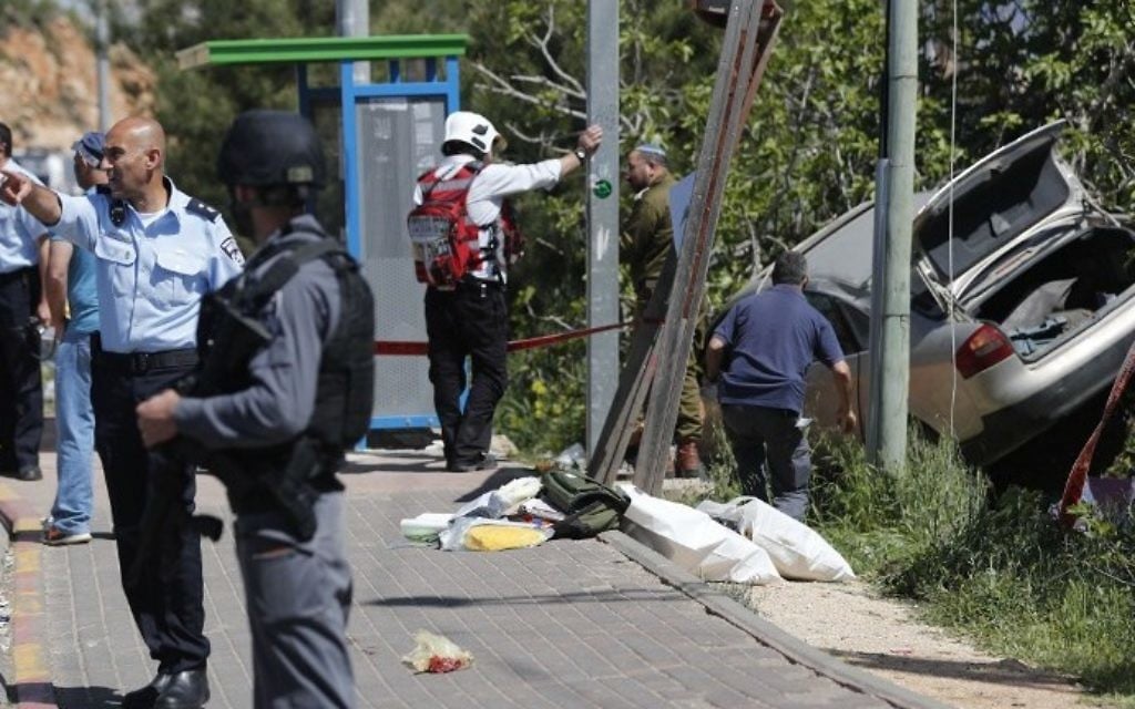 Israeli security forces inspect the site of a car ramming attack outside the Israeli West Bank Settlement of Ofra on April 6, 2017. (AFP Photo/Thomas Coex)