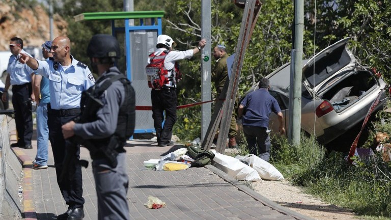 Israeli security forces inspect the site of a car ramming attack outside the Israeli West Bank Settlement of Ofra on April 6, 2017. (AFP Photo/Thomas Coex) Israeli security forces inspect the site of a car ramming attack outside the Israeli West Bank Settlement of Ofra on April 6, 2017. (AFP Photo/Thomas Coex)