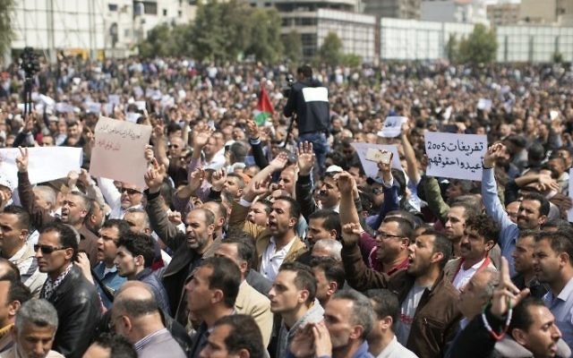 Palestinian Authority employees chant slogans and wave placards during a demonstration against the decision by the PA to reduce their salaries in Gaza City on April 8, 2017. (AFP Photo/Mahmud Hams) Palestinian Authority employees chant slogans and wave placards during a demonstration against the decision by the PA to reduce their salaries in Gaza City on April 8, 2017. (AFP Photo/Mahmud Hams)