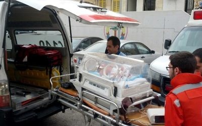 Lebanese Red Cross members wheel a baby in an neonatal intensive care unit (NICU) into an ambulance during clashes in Ain al-Hilweh camp, Lebanon's largest Palestinian refugee camp, near the southern coastal city of Sidon, on April 8, 2017. (AFP/Mahmoud Zayyat)