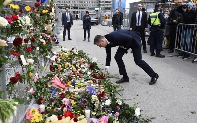 Swedish Social democrat politician Anders Ygeman lays flowers at a makeshift memorial near the site where a truck slammed into a crowd yesterday outside a busy department store, in central Stockholm, on April 8, 2017. (AFP PHOTO / Jonathan NACKSTRAND)