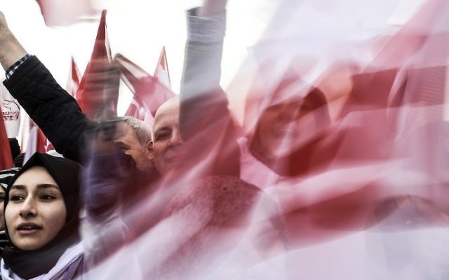 People wave "YES" banners and Turkish national flags on April 8, 2017 during a campaign rally for the "yes" vote in a constitutional referendum in Istanbul. (AFP PHOTO / BULENT KILIC)
