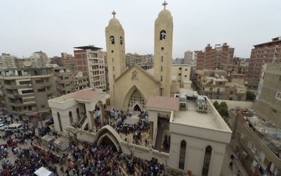 A general view shows people gathering outside the Mar Girgis Coptic Church in the Nile Delta City of Tanta, 120 kilometers (75 miles) north of Cairo, after a bomb blast struck worshippers gathering to celebrate Palm Sunday, April 9, 2017. (AFP/Khaled Desouki)