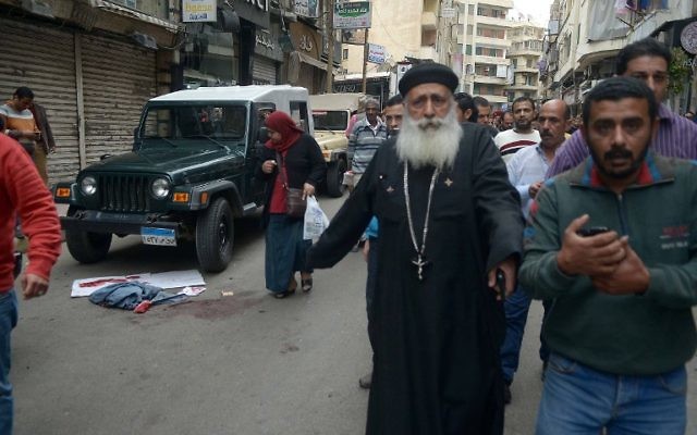 Egyptians walk past bloodstains in a street near a church in Alexandria after a bomb blast struck worshippers gathering to celebrate Palm Sunday on April 9, 2017. ( AFP PHOTO / STRINGER) Egyptians walk past bloodstains in a street near a church in Alexandria after a bomb blast struck worshippers gathering to celebrate Palm Sunday on April 9, 2017. ( AFP PHOTO / STRINGER)