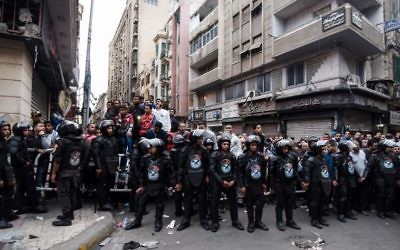 Egyptians gather behind a security perimeter near the Coptic Orthodox Patriarchate in Alexandria after a bomb blast struck outside the church as worshipers attended Palm Sunday mass on April 9, 2017. (AFP/MOHAMED EL-SHAHED)