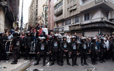 Egyptians gather behind a security perimeter near the Coptic Orthodox Patriarchate in Alexandria after a bomb blast struck outside the church as worshippers attended Palm Sunday mass on April 9, 2017. (AFP PHOTO / MOHAMED EL-SHAHED)