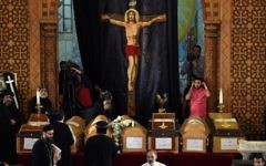 Coptic priests stand near the coffins of victims of the blast at the Coptic Christian Saint Mark's church in Alexandria the previous day during a funeral procession at the Monastery of Marmina in the city of Borg El-Arab, east of the northern port city on April 10, 2017. (AFP Photo/Mohamed El-Shahed)