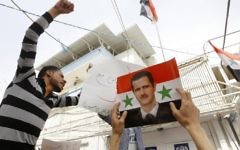 Syrian protesters take part in a demonstration outside the United Nations office in the capital Damascus, on April 11, 2017, in support of the country's strongman Bashar Assad, depicted in the portrait. (AFP Photo/Louai Beshara)