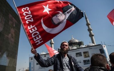 A man waves a flag with a portrait of Turkish President Recep Tayyip Erdogan on April 11, 2017 during a "yes" campaign event in Istanbul's Eminonu district. (AFP PHOTO / OZAN KOSE)