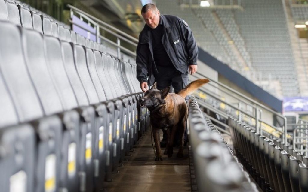 A policeman and an explosive detection sniffer dog do their work at the stadium in Dortmund, western Germany, on April 12, 2017 prior to the UEFA Champions League quarter-final, first-leg football match of German first division Bundesliga club Borussia Dortmund vs Monaco. (AFP PHOTO / DPA / Guido Kirchner)