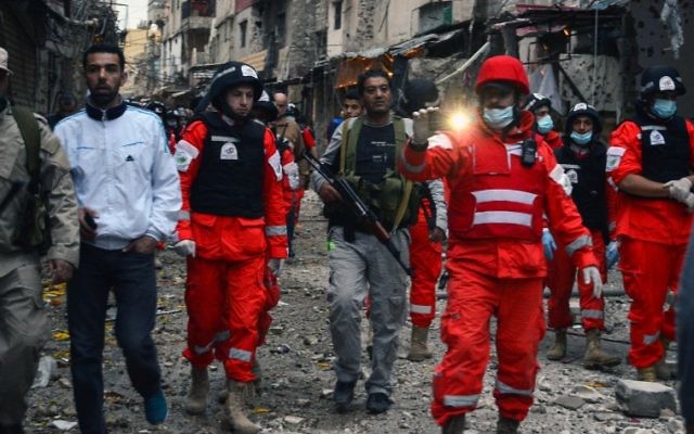 Paramedics walk amid the destruction after clashes that took place earlier in the week between an extremist group and a Palestinian security force, in Ain al-Hilweh refugee camp, near the southern coastal city of Sidon, April 12, 2017. (AFP/STRINGER)