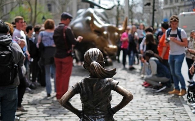 The "Fearless Girl" (front) statue stands facing the "Charging Bull" as tourists take pictures in New York on April 12, 2017. (AFP/ Jewel SAMAD) The "Fearless Girl" (front) statue stands facing the "Charging Bull" as tourists take pictures in New York on April 12, 2017. (AFP/ Jewel SAMAD)