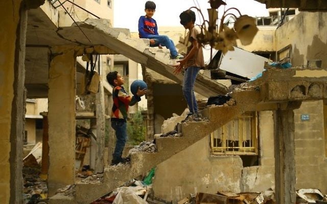 Palestinian children play amidst the ruins of a building destroyed during the 50-day war between Israel and Hamas militants during the summer of 2014 in Gaza City, on April 13, 2017. (Mohammed Abed/AFP) Palestinian children play amidst the ruins of a building destroyed during the 50-day war between Israel and Hamas militants during the summer of 2014 in Gaza City, on April 13, 2017. (Mohammed Abed/AFP)