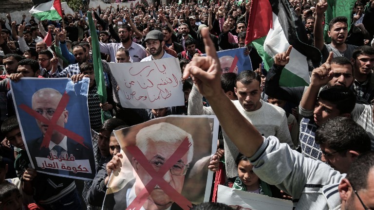 Gaza supporters of the Palestinian Hamas movement hold crossed-out portraits of Palestinian leader Mahmud Abbas (C) and prime minister Rami Hamdallah during a protest on April 14, 2017, in Khan Yunis. (AFP PHOTO / SAID KHATIB) Gaza supporters of the Palestinian Hamas movement hold crossed-out portraits of Palestinian leader Mahmud Abbas (C) and prime minister Rami Hamdallah during a protest on April 14, 2017, in Khan Yunis. (AFP PHOTO / SAID KHATIB)