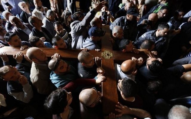 Christian pilgrims carry a wooden cross as they enter the Church of the Holy Sepulchre in Jerusalems Old City during the Good Friday celebrations on April 14, 2017. (AFP/ GALI TIBBON)