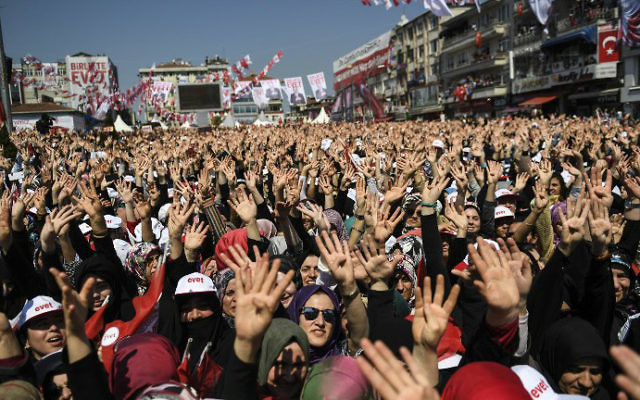 000_NK7CG People cheer as Turkey's president delivers a speech on the eve of the constitutional referendum, on April 15, 2017 in Istanbul. (Bulent Kilic/AFP)