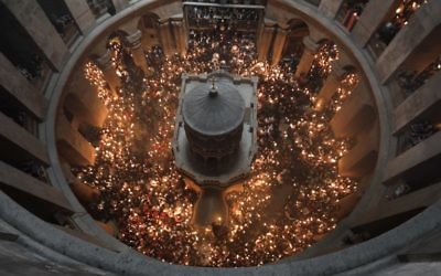 Christian Orthodox worshippers hold up candles during the ceremony of the 'Holy Fire' as thousands gather in the Church of the Holy Sepulchre in Jerusalem's Old City, on April 15, 2017, during Orthodox Easter ceremonies. (AFP/Menahem Kahana)