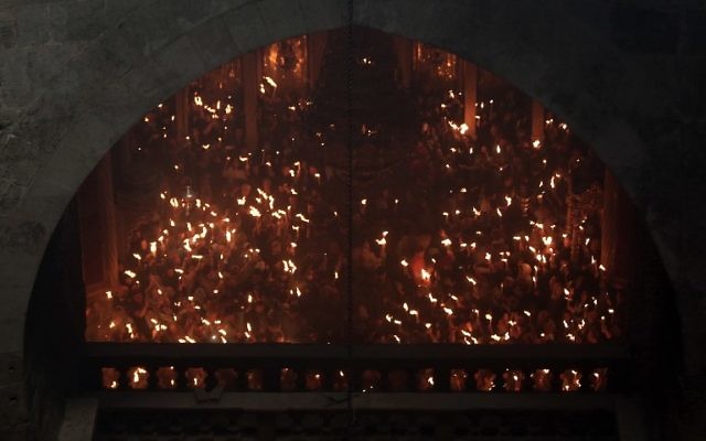Christian Orthodox worshipers hold up candles during the ceremony of the "Holy Fire" as thousands gather in the Church of the Holy Sepulchre in Jerusalem's Old City, on April 15, 2017, during the Orthodox Easter holy week. (AFP PHOTO / MENAHEM KAHANA)