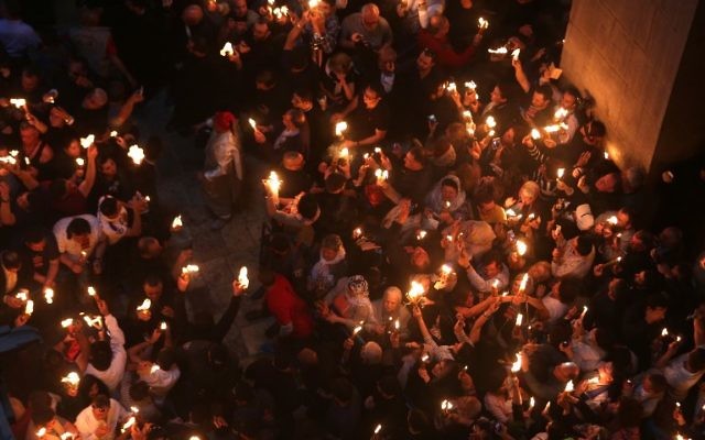 Christian Orthodox worshipers hold up candles during the ceremony of the "Holy Fire" as thousands gather in the Church of the Holy Sepulchre in Jerusalem's Old City, on April 15, 2017, during the Orthodox Easter holy week. ( AFP PHOTO / MENAHEM KAHANA)