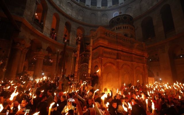 Christian Orthodox worshipers hold up candles during the ceremony of the "Holy Fire" as thousands gather in the Church of the Holy Sepulchre in Jerusalem's Old City, on April 15, 2017, during Orthodox Easter ceremonies (AFP PHOTO / GALI TIBBON)