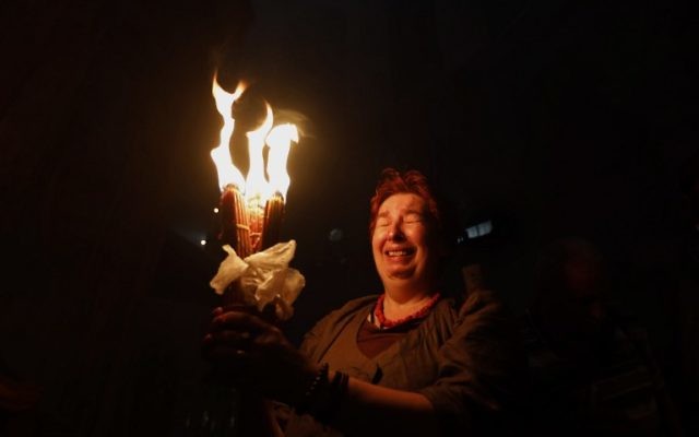 A Christian Orthodox worshiper holds candles during the ceremony of the "Holy Fire" as thousands gather in the Church of the Holy Sepulchre in Jerusalem's Old City, on April 15, 2017, during the Orthodox Easter holy week. (AFP PHOTO / GALI TIBBON)