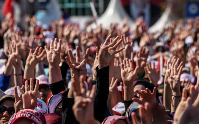 People cheer and flash a four-finger sign called "the rabia sign" as the Turkish president delivers a speech in Istanbul, on April 15, 2017, during a rally on the eve of the constitutional referendum. (Ozan Kose/AFP) People cheer and flash a four-finger sign called "the rabia sign" as the Turkish president delivers a speech in Istanbul, on April 15, 2017, during a rally on the eve of the constitutional referendum. (Ozan Kose/AFP)