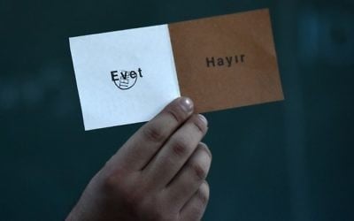 An electoral official shows a "Yes" vote as they count ballot boxes after the polls closed during the referendum on expanding the powers of the president on April 16, 2017 in Istanbul. (AFP Photo/Ozan Kose)