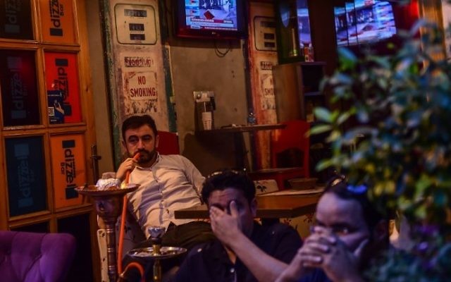 A man smokes a water pipe as others follow the referendum results on television near Taksim square in Istanbul on April 16, 2017. (AFP Photo/Yasin Akgul) A man smokes a water pipe as others follow the referendum results on television near Taksim square in Istanbul on April 16, 2017. (AFP Photo/Yasin Akgul)