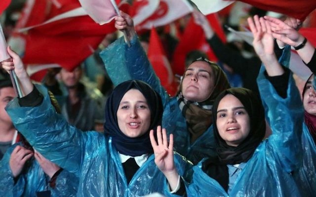 Supporters of Turkey's president flash a four fingers sign called "the rabia sign" as they wave Turkish flags and flags reading "yes" during a rally near the headquarters of the conservative Justice and Development Party (AKP) on April 16, 2017 in Ankara. (AFP Photo/Adem Altan) Supporters of Turkey's president flash a four fingers sign called "the rabia sign" as they wave Turkish flags and flags reading "yes" during a rally near the headquarters of the conservative Justice and Development Party (AKP) on April 16, 2017 in Ankara. (AFP Photo/Adem Altan)