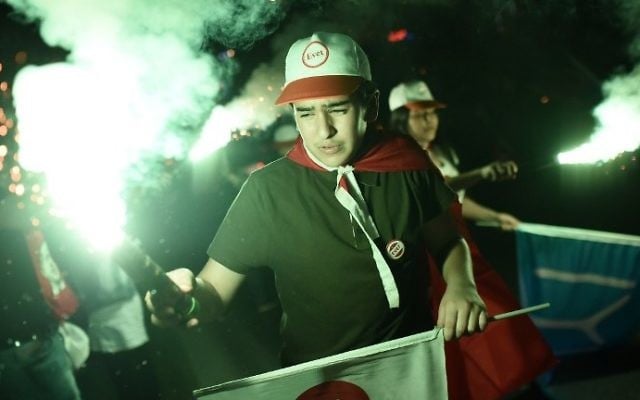 A supporter of Turkey's president wearing a cap reading "yes" holds a smoke bombs during a rally near the headquarters of the conservative Justice and Development Party (AKP) on April 16, 2017 in Istanbul. (AFP Photo/Ozan Kose)