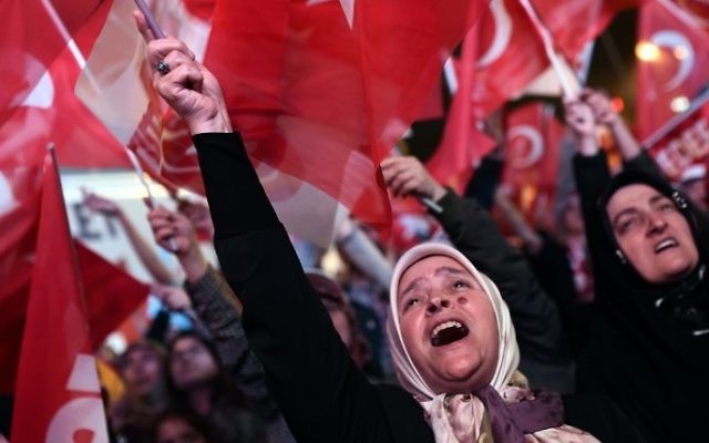 A woman supporting the Turkish president waves a Turkish national flag as she celebrates during a rally near the headquarters of the conservative Justice and Development Party (AKP) on April 16, 2017 in Istanbul after the results of a nationwide referendum (AFP PHOTO / OZAN KOSE)