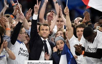 Presidential election candidate for the En Marche ! movement Emmanuel Macron flashes the "V for victory" sign surrounded with his supporters after delivering a speech during a campaign meeting on April 17, 2017 at the Bercy Arena in Paris. (AFP PHOTO / Eric FEFERBERG)